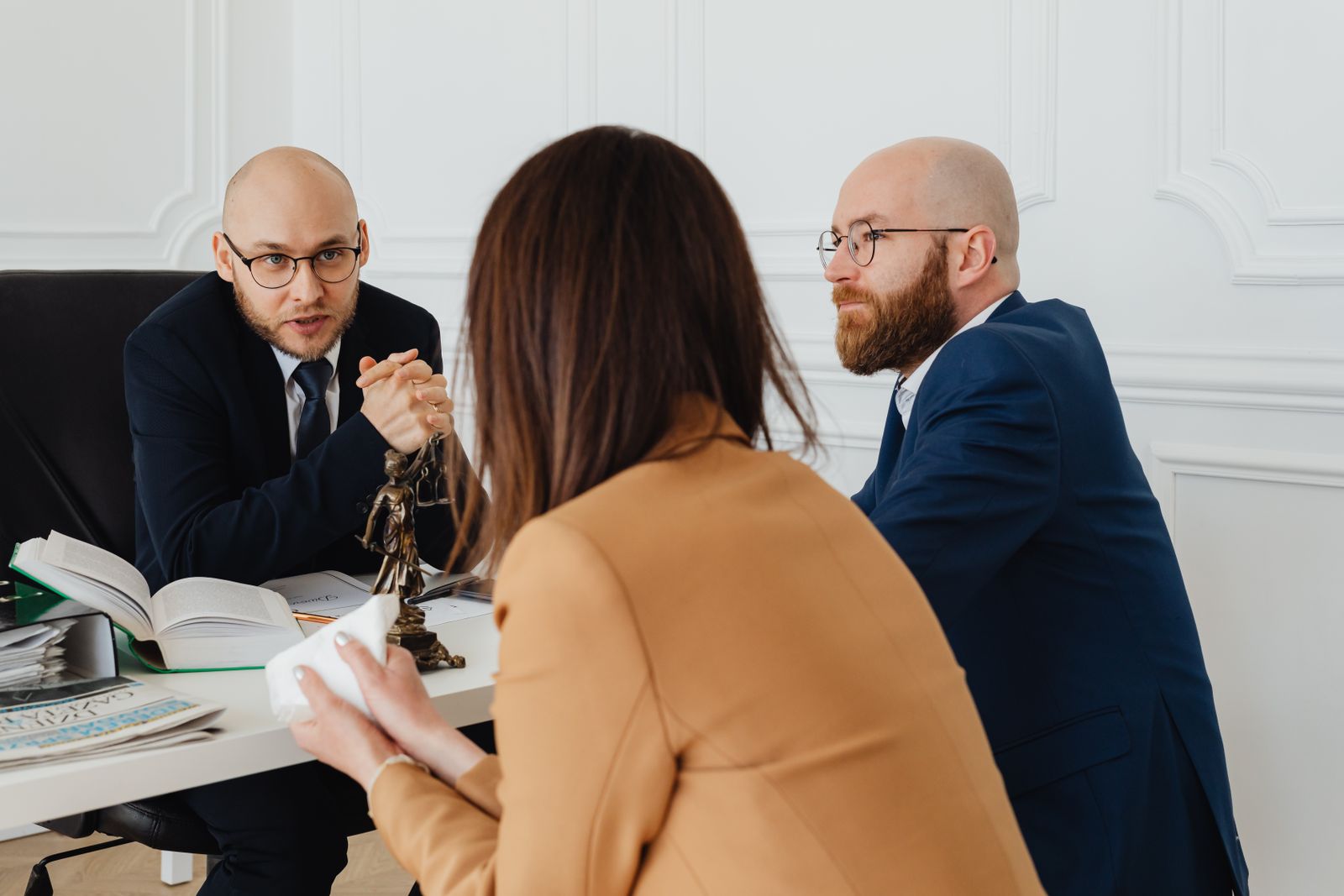 Attorneys advising a client at a conference table in a law office